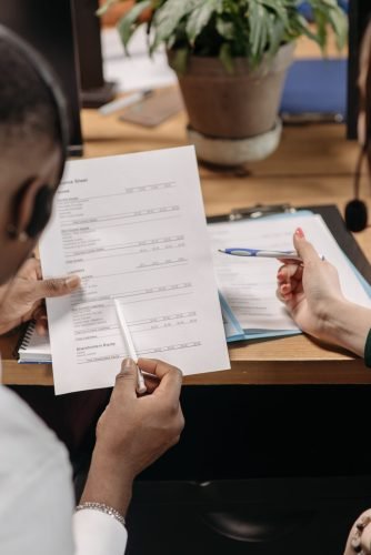 Two professionals reviewing financial documents and discussing strategy in an office environment.